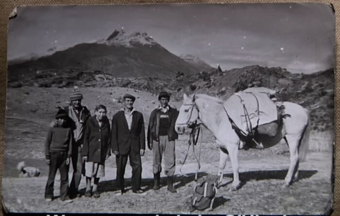 black and white family with a horse in front of a mountainous background